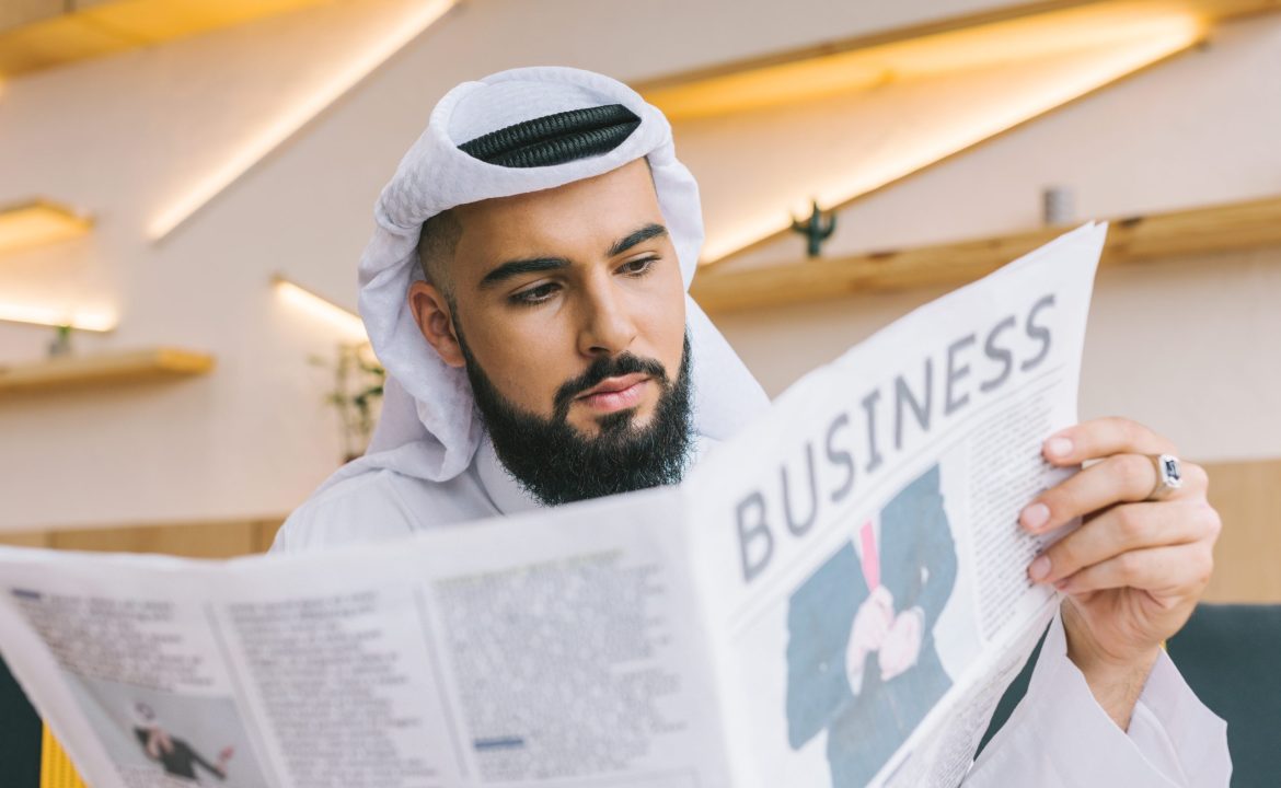 close-up shot of serious muslim businessman reading newspaper