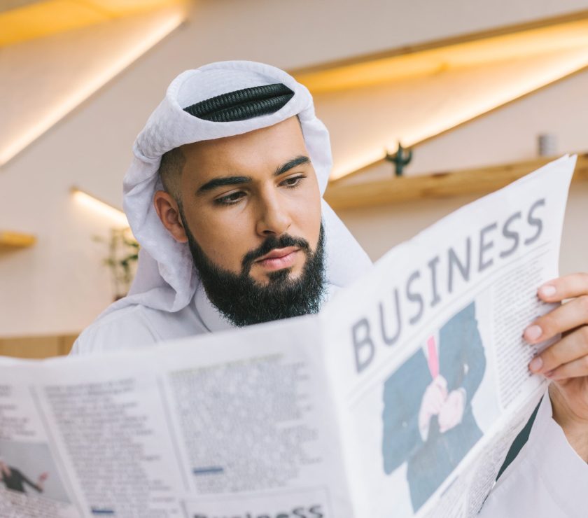 close-up shot of serious muslim businessman reading newspaper