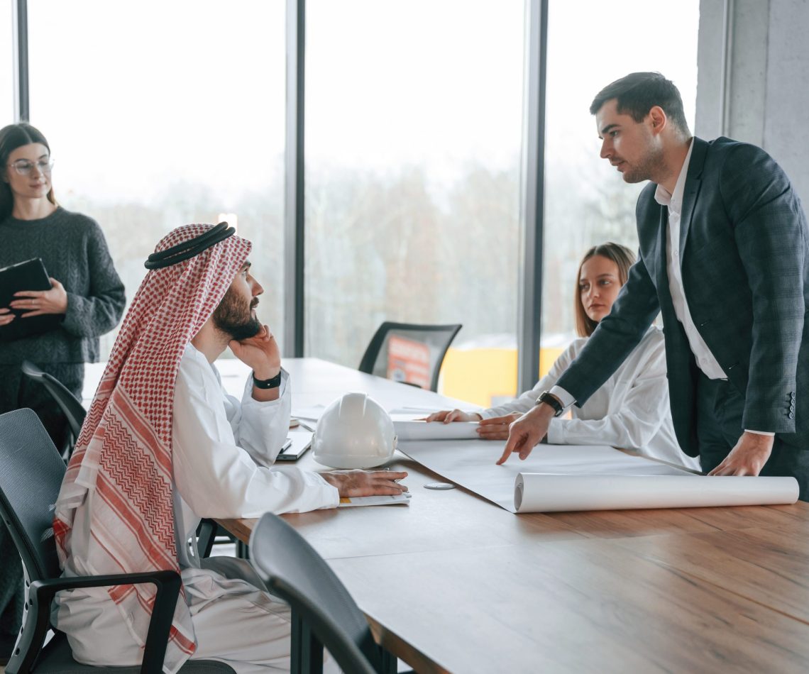 Conception of teamwork. Muslim businessman in traditional outfit with colleagues in office