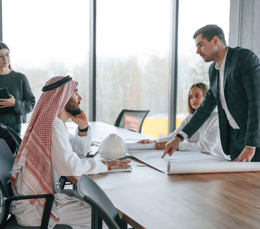 Conception of teamwork. Muslim businessman in traditional outfit with colleagues in office