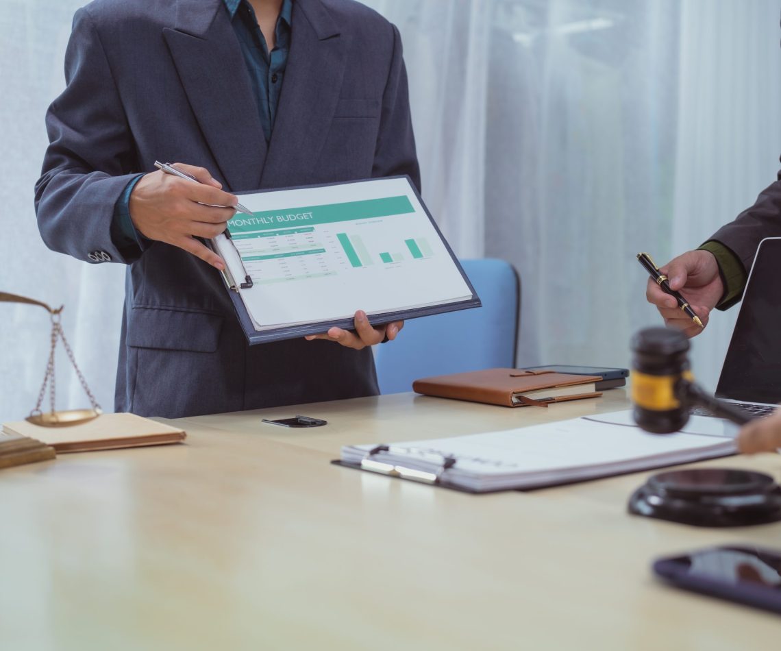 Three lawyers in a meeting at the table in an office, discussing
