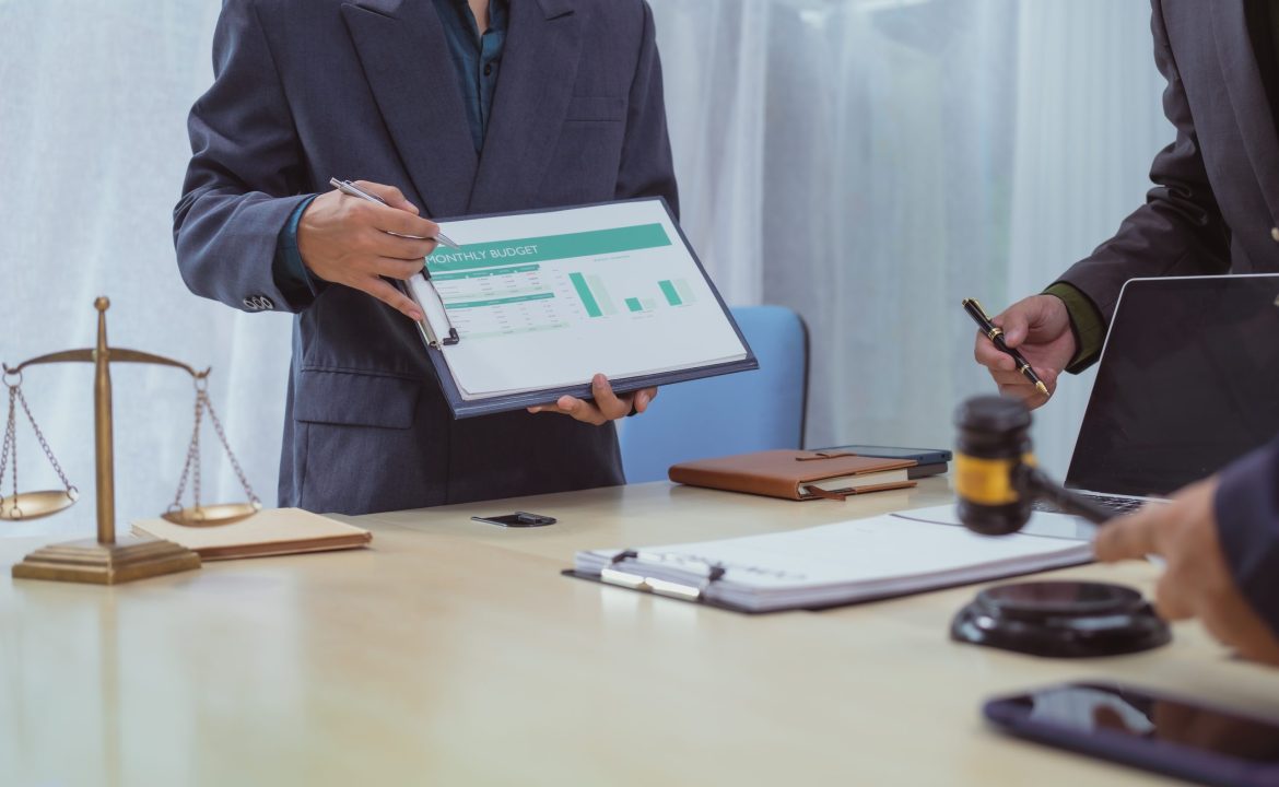 Three lawyers in a meeting at the table in an office, discussing