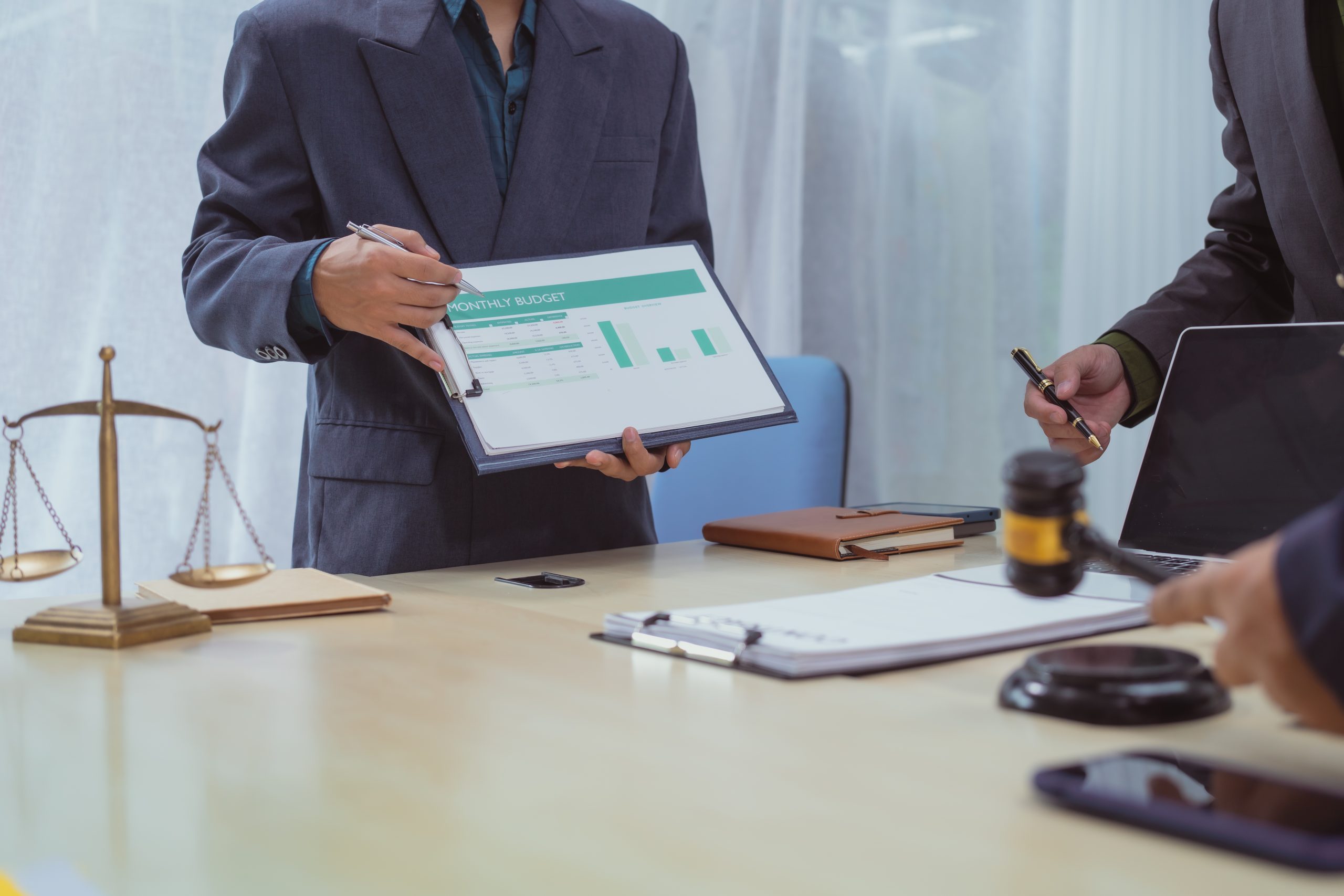 Three lawyers in a meeting at the table in an office, discussing