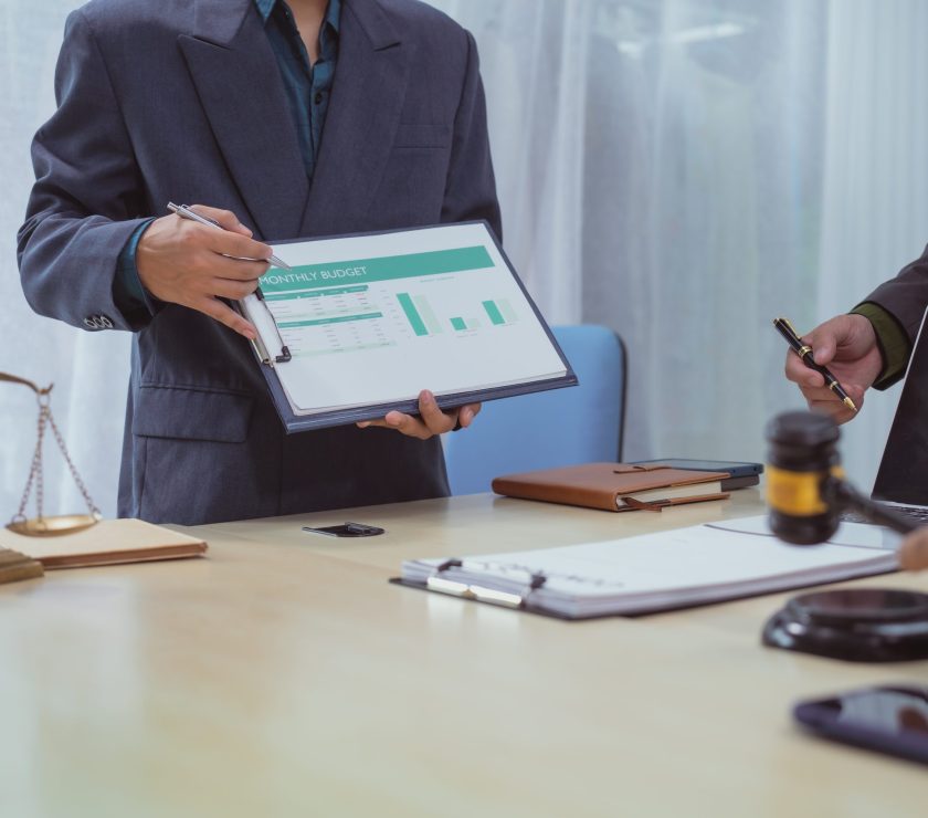 Three lawyers in a meeting at the table in an office, discussing