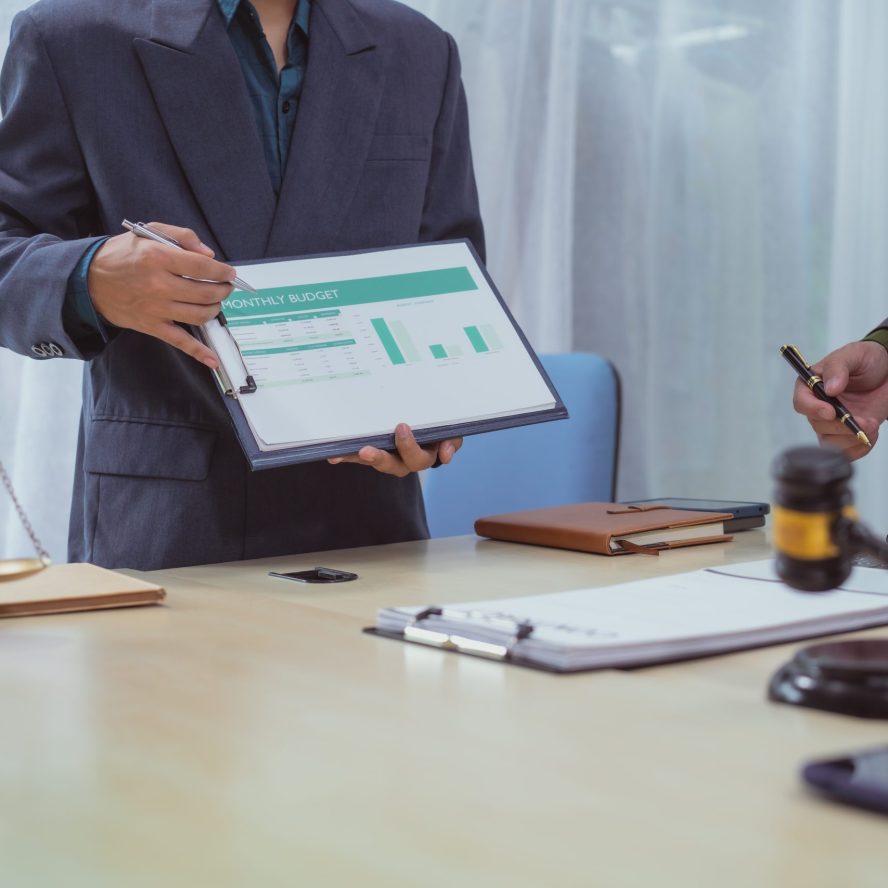Three lawyers in a meeting at the table in an office, discussing